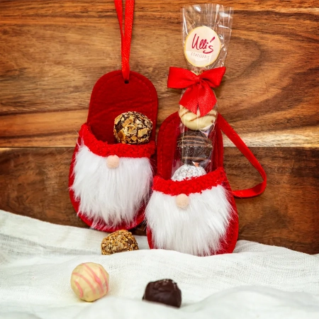 Ulli's handgemachte Pralinen in einem roten Nikolaus-Pantoffel aus Filz. Der Nikolaus hat einen weißen Vollbart und eine kleine Stupsnase.